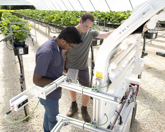 Two students operating a robotic farming machine